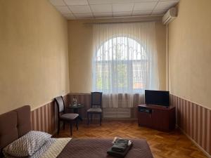 um quarto com uma cama, uma mesa e uma janela em Barvy Dnipra em Dnipro