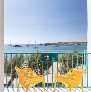 two chairs and a table on a balcony overlooking the water at Play Paros in Kampos Paros