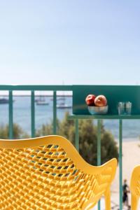 a yellow wicker chair sitting in front of a table at Play Paros in Kampos Paros