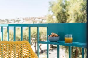 a blue table with a bowl of food and a glass of orange juice at Play Paros in Kampos Paros
