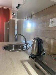 a tea kettle sitting on top of a kitchen sink at City Residence Apartments Sofia in Sofia