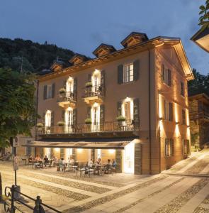 a building with people sitting at tables in front of it at Rivalago B&B in Cannobio