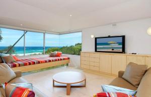 a living room with a couch and a flat screen tv at 38 Seaview Terrace, Sunshine Beach in Noosa Heads