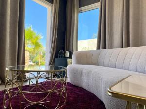 a living room with a couch and a glass table at Bella Vista Hôtel, Suites & Maisons in Porticcio