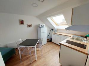 cocina con mesa y cocina pequeña con ventana en Appartements cosy BELFORT, en Belfort