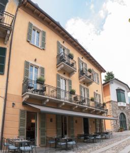 a building with tables and chairs in front of it at Rivalago B&B in Cannobio