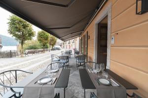 un restaurante con mesas y sillas en un patio en Rivalago B&B en Cannobio