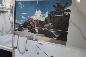 - une salle de bains avec une photo de plage dans l'établissement Appart. T2 de luxe +jacuzzi, vue mer et côté plage, au Gosier