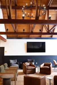 a lobby with couches and a flat screen tv at The Lodge at Lincoln Peak at Sugarbush in Warren