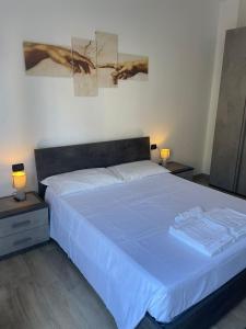 um quarto com uma cama com lençóis azuis e 2 candeeiros em Accogliente Loft ben servito em Novara