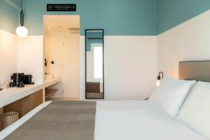 a bedroom with a white bed and a mirror at Play Paros in Kampos Paros