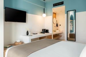a bedroom with a bed and a tv on the wall at Play Paros in Kampos Paros