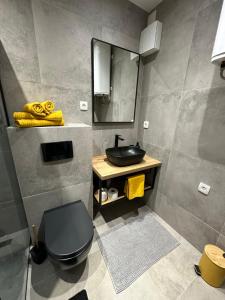 a bathroom with a black toilet and a sink at Apartment Luce in Lovran