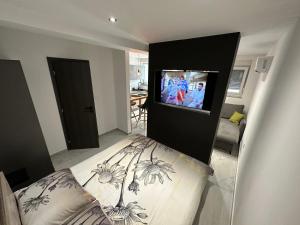 een slaapkamer met een bed en een tv aan de muur bij Apartment Luce in Lovran
