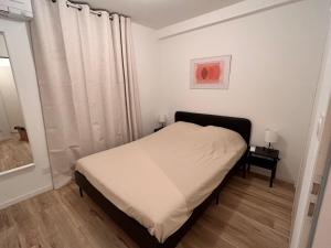 ein kleines Schlafzimmer mit einem Bett und einem Fenster in der Unterkunft Bel appartement climatisé 2 chambres à 20m du Vieux-Port in Marseille