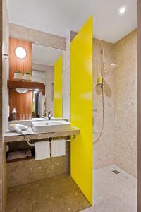 a bathroom with a sink and a shower at Hey Lou Hotel Monheim am Rhein in Monheim