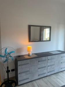 a room with a dresser with a fan and a mirror at Accogliente Loft ben servito in Novara
