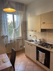 a kitchen with a stove and a sink and a window at Accogliente Loft ben servito in Novara