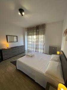 um quarto com uma grande cama branca e uma janela em Accogliente Loft ben servito em Novara