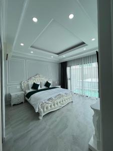 una camera da letto bianca con un grande letto bianco con cuscini neri di Khách sạn Chè yến Nha Trang a Nha Trang