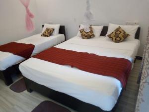 two twin beds in a room with at Natural View Home in Sigiriya