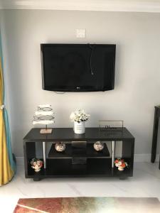 een zwarte salontafel met een flatscreen-tv aan de muur bij The Havens hideaway in Freeport