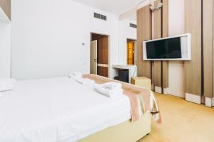 ママイアにあるHotel Scandinavia Mamaiaのベッド1台、薄型テレビが備わるホテルルームです。