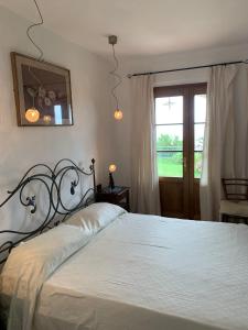 - une chambre dotée d'un grand lit avec des draps blancs et une fenêtre dans l'établissement La Terrazza sulla Versilia, à Vitoio