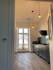 a kitchen with a large window and a counter top at les croix appartements in Morlaix +6 photos