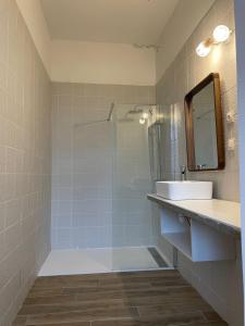 La salle de bains est pourvue d'une douche, d'un lavabo et d'un miroir. dans l'établissement les croix appartements, à Morlaix
