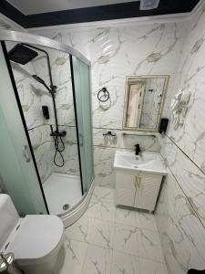 y baño con lavabo, ducha y aseo. en New Minor Hotel en Khiva