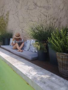 a person sitting on a couch reading a book at Les Tilleuls in Cavaillon
