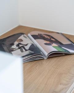 an open magazine sitting on a wooden table at Play Paros in Kampos Paros