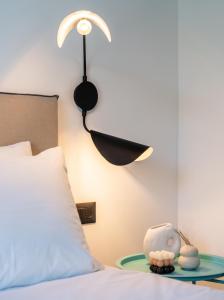 a bedroom with a bed with a lamp on the wall at Play Paros in Kampos Paros