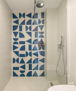 a bathroom with a blue and white patterned wall at Play Paros in Kampos Paros