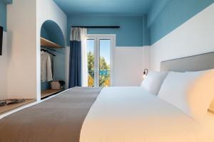 a bedroom with a large bed and a window at Play Paros in Kampos Paros