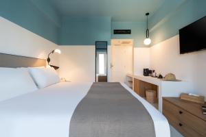 a bedroom with a large bed and a tv at Play Paros in Kampos Paros