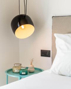 a lamp on a table next to a bed at Play Paros in Kampos Paros