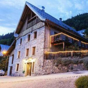 a large stone building with a balcony on it at Apartment Les Rousses 3 minutes from Alpe dHuez Grand Domaine via Oz en Oisans in Oz