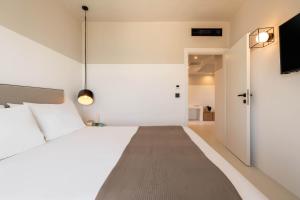a bedroom with a white bed and a tv at Play Paros in Kampos Paros
