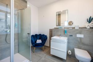a bathroom with a blue chair next to a sink and a shower at Strandvilla Glückauf in Binz +77 photos