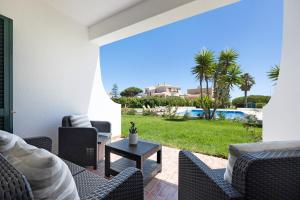 a patio with chairs and a table and a pool at Apartamento Navegador in Sagres