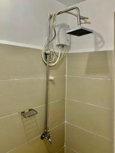a shower in a bathroom with a shower head at JC Condo, SMDC Green Malate Taft Manila in Manila