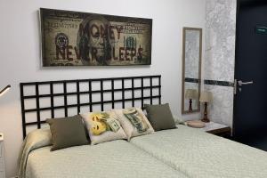 a bedroom with a bed and a picture on the wall at Apto. Singular en la Mancha Banco de Inversiones in Argamasilla de Alba