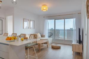 Myflats Premium Beach Front في آريناليس ديل سول: غرفة معيشة بها أريكة وطاولة عليها فاكهة