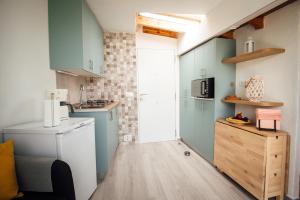 a small kitchen with blue cabinets and a washer at Casa Tulipanes & Spa in Santa Cruz de Tenerife