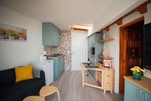 サンタクルス・デ・テネリフェにあるCasa Tulipanes & Spaの小さなリビングルーム(ソファ付)、キッチンが備わります。