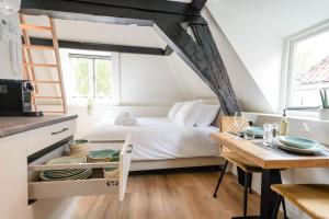ein Schlafzimmer mit einem Bett und einem Tisch mit Geschirr darauf in der Unterkunft Beautiful Apartment With Loft in Delft