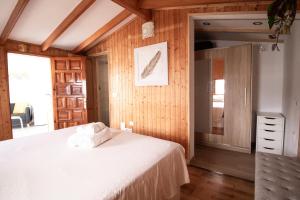 um quarto com uma cama branca e paredes de madeira em Casa Tulipanes & Spa em Santa Cruz de Tenerife