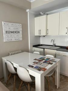 eine weiße Küche mit einem weißen Tisch und Stühlen in der Unterkunft alojamientosteruelmarqueses El Marqués in Teruel